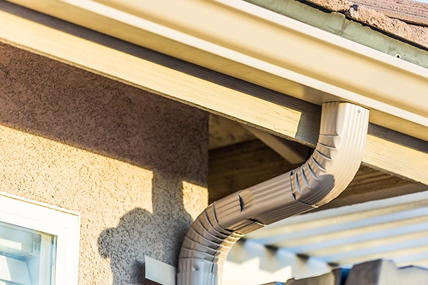 stucco house with new seamless aluminum gutter and downspout