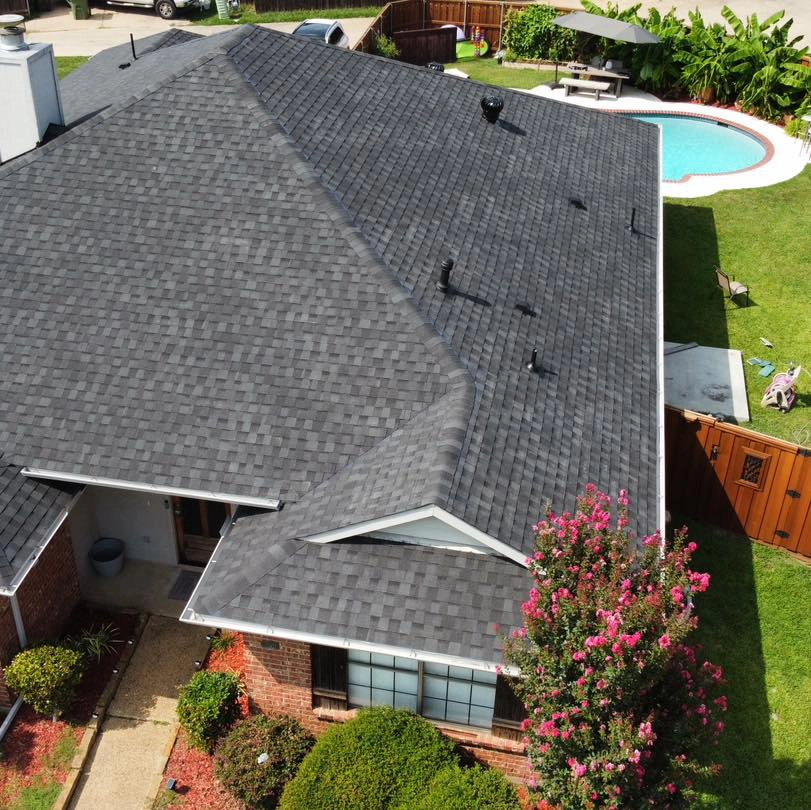 arial view of a red brick house with a pool in the backyard that has a new dark gray roof